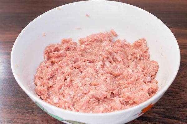 把醬油、玉米粉、糖、鹽、白胡椒粉、料理酒加入豬肉中拌勻，邊依同一方向攪拌邊續少加入雞高湯，拌至肉把湯汁完全吸收。