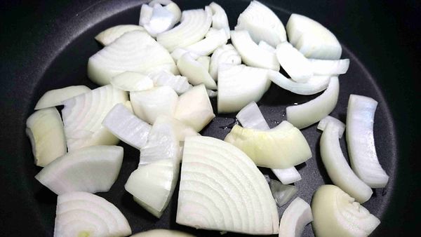 取出平底鍋，倒入少許油，將洋葱放入，開中火慢煎。