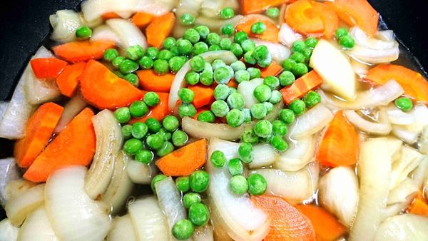 倒入雞汁和水（約蓋過鍋內食材的水量即可），放入冷凍豌豆，蓋鍋蓋慢燉。