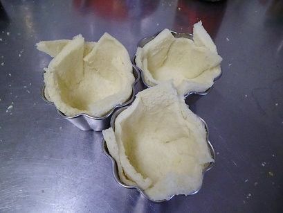 型杯先抹上一點奶油(烤好比較好脫模)....土司壓入模型杯裡