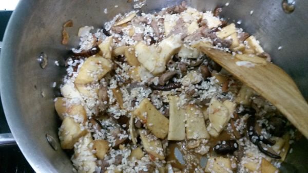 接著將米倒入拌炒，加入香菇水，等香菇水份略乾後，加水至略高於食材；等水滾後，轉小火煮至米爛即可。