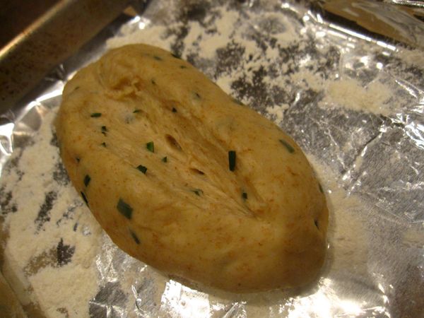 用一把利刀，把麵團中間切出1/3深，稍微撥開