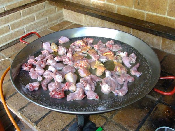 1、加入橄欖油。( 橄欖油才會比較香唷！）
2、放入『雞肉』與『兔肉』。若不敢吃兔肉的朋友，也可以換成『豬肉』或『鴨肉』，只是要記得比例， 一定是『雞肉要比較多，約佔肉類的三分之二』，其他另一種肉品則只佔『三分之一』。
3、並灑入微多的鹽巴。
4、開大火先把雞肉煎的金黃色。