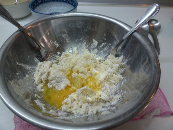 繼續加入打散的雞蛋，用叉子攪拌，看不到麵粉粒即可，不要攪過久，避免出筋