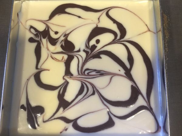 牛奶煮熱，加入巧克力中混合均勻備用

奶油乳酪室溫下退冰後打軟
依序加入砂糖、檸檬汁、酸奶、雞蛋拌勻
（逐項拌勻後才可加入下一項材料）

將巧克力糊中加入ㄧ大匙乳酪餡拌勻備用

乳酪餡倒入模內，於表面擠上些許巧克力糊
再以竹籤隨意拉出漂亮的花樣