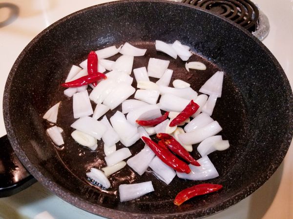 熱鍋加1匙油，將蒜片、洋蔥、乾辣椒下鍋爆香，再把雞肉、香菇、紅蘿蔔放入快炒，可加少許的水煨炒一下，以鹽及1匙的醬油調味，最後放入蔥段拌勻，美味的鮮香菇炒嫩雞就完成了哦!