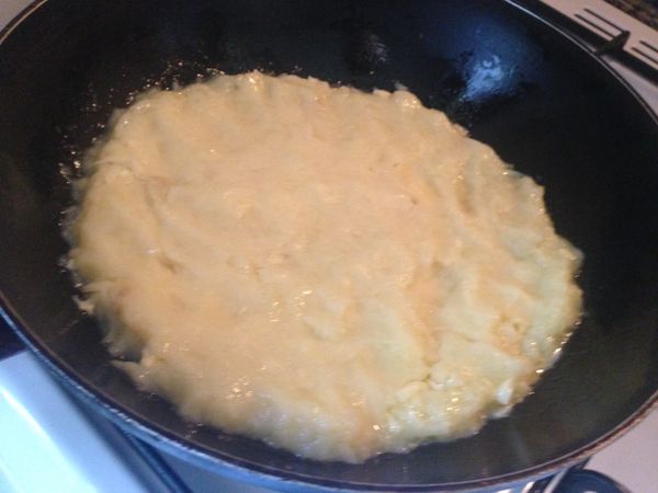 再將剩下一半的薯泥，一小塊一小塊地鋪上，也是用拳頭壓緊，周圍可以用木鏟整理好，然後開火，中火開始油煎薯餅，3分鐘以後要前後搖晃平底鍋，確定沒有黏鍋，然後確定煎到底部焦黃，才用一個大過平底鍋的平盤，整個翻倒在平盤上，焦黃的面朝上，然後平底鍋裡再度放入奶油橄欖油，再將薯餅推入鍋中，這個會有點兒難～