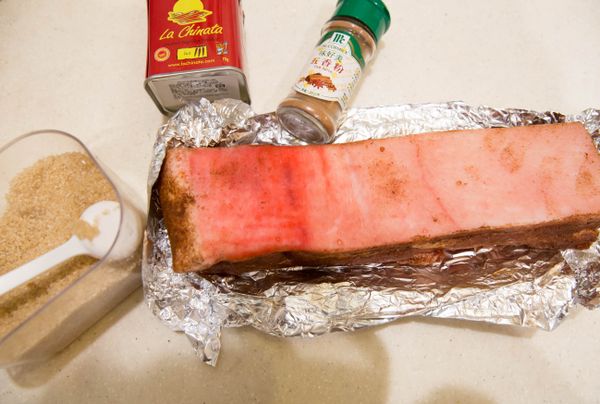 五香粉、二砂糖、海鹽、辣紅椒粉放入碗裡混合均勻成醃料;再把這醃料抹在除了豬皮之外的豬肉四周和底部,再用鋁箔紙把四周包起來要露出豬皮喔!放入冰箱冷藏一晚,這樣是可以是表皮的水分被冰箱稍微吸乾,烤出來的豬皮才會脆