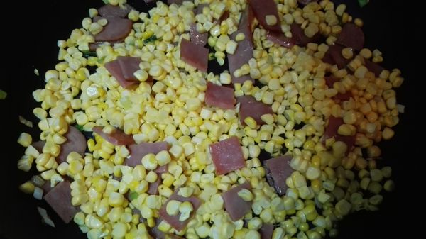 用刀切下玉米上的玉米粒，下鍋加些許水，翻炒至玉米熟軟。