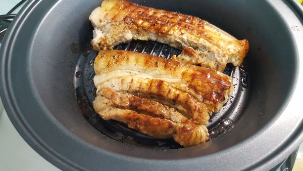 大概4~5分鐘翻個面，再繼續煎烤4~5分鐘，直到兩面都上色熟透（筷子可輕易插入）。過程中豬油會流到旁邊溝槽，瀝油整個健康許多。