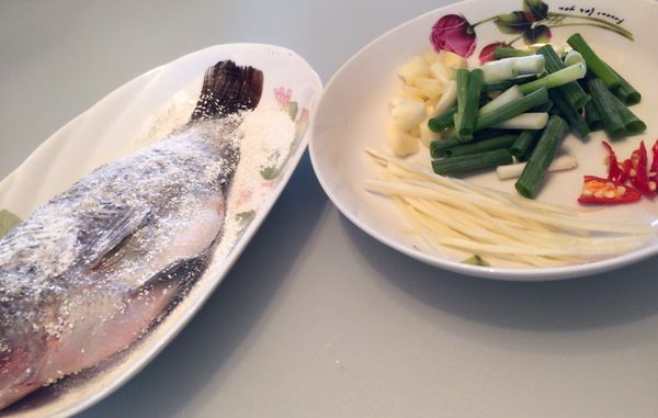 將蒜頭拍碎切小塊，薑切絲，蔥切段，辣椒切斜段備用。
將魚裹上地瓜粉。