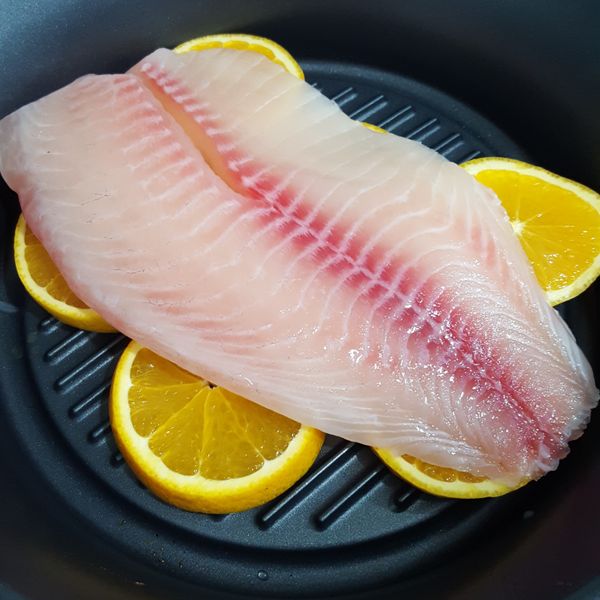 香橙鋪底，鯛魚片放上，淋上些許米酒去腥