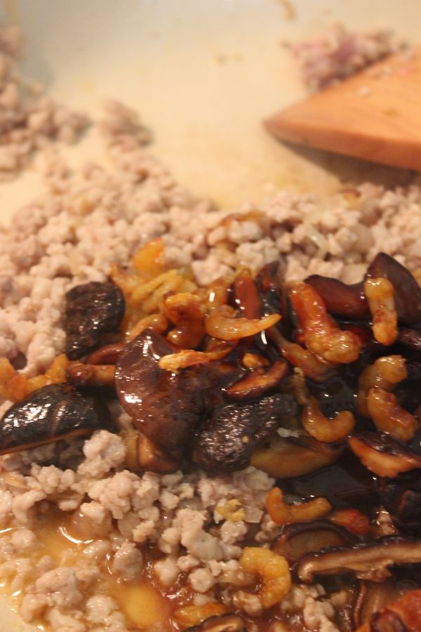 將香菇與蝦米放回鍋中~下蔭油膏與醬油同炒~炒至食材均上色~下點白胡椒再同炒