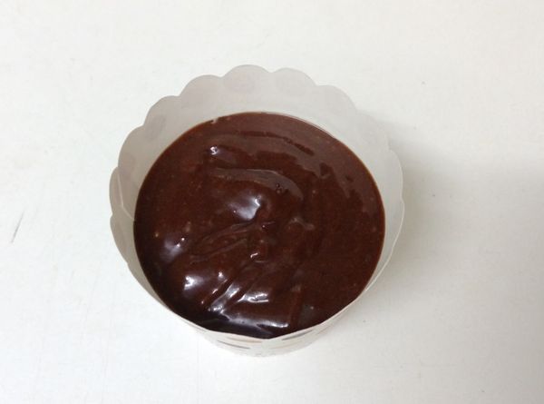 將麵糊倒入紙杯模裡約７分滿，並輕敲出氣泡。