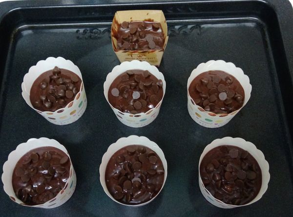 在麵糊表面撒些巧克力豆，最後送進已預熱１８０度Ｃ的烤箱烤約１５分鐘。用筷子插入蛋糕中心不沾麵糊即烤熟。