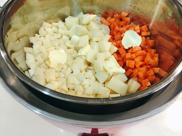 將切塊的馬鈴薯與紅蘿蔔放進電鍋，加一些奶油，倒兩杯半的水蒸熟並放涼