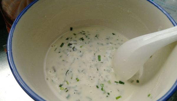 把蔥花或韭菜末加入粉漿裡頭，拌勻。