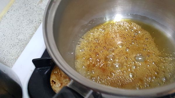 焦糖煮到全部變比金黃色稍深，搖鍋均勻，有白煙出現，馬上離火。
離火的焦糖馬上分入耐熱布丁杯中，動作要迅速，因為焦糖很快就會硬化。（所以煮焦糖時，要先把布丁杯放在旁邊備用）