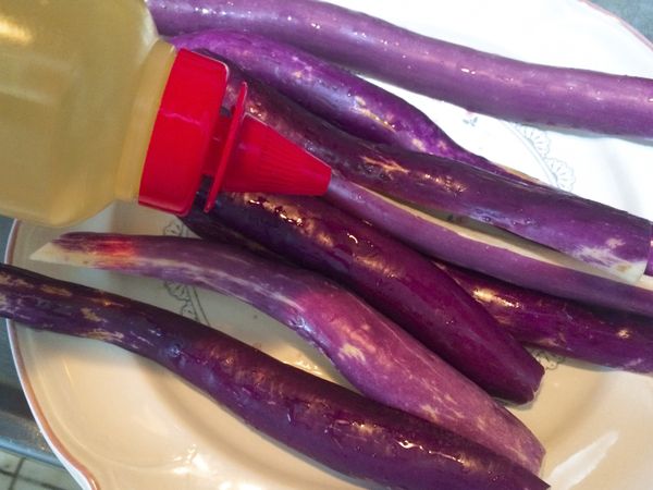 在茄子面上淋上少許油脂，用手把油抹勻在茄子面上，一定要確實抹好