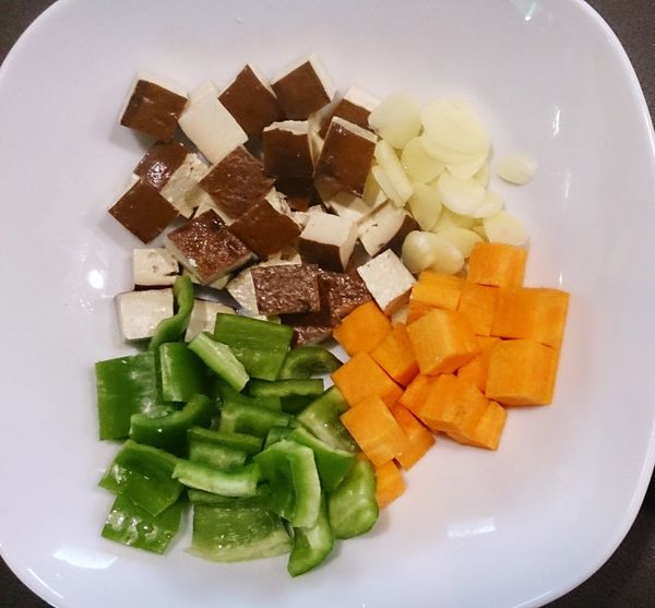將豆干、青椒、胡蘿蔔切丁，蒜頭切片