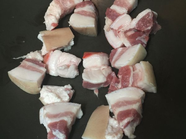 將帶皮五花肉切塊並將較多油脂的五花肉先下鍋乾煎