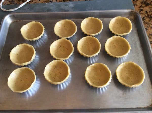 取出冷藏的塔皮，分為12等分，搓成圓球後按扁成為片狀，舖入塔模內，用指腹推開成為塔皮，要略高於塔模。並用义子戳洞。再次冷藏30分鐘。350°F烤15-20分鐘。