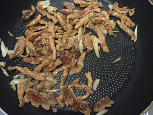 爆香洋蔥後加入醃好的肉絲拌炒，炒約兩分鐘