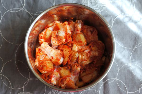 將泡菜與小雞翅拌勻，冷藏醃漬一晚。