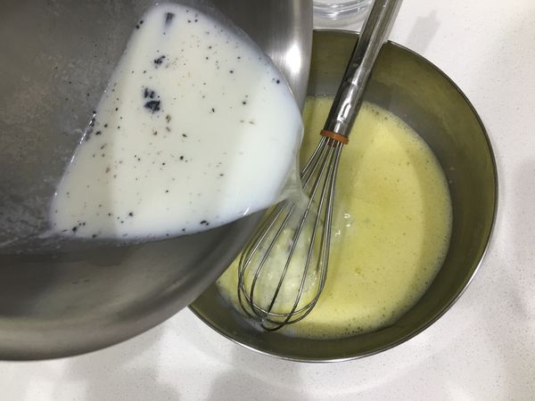 將煮好的鮮奶液倒入攪拌好的蛋黃糊裡。