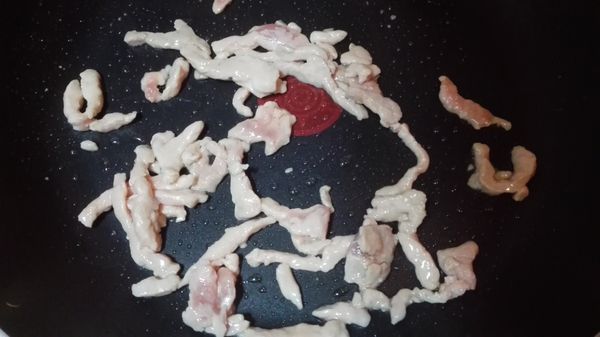 起鍋放入豬肉絲，炒至反白，盛盤備用。