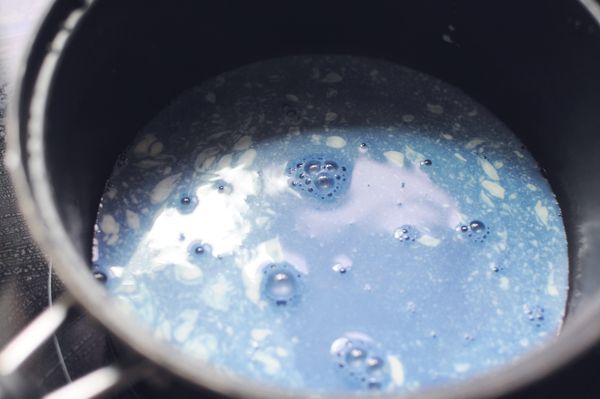 將蝶豆花水煮沸，加糖和鹽煮至溶化，再拌入鮮奶油。然後不斷攪拌直至煮成半凝固狀就可以了，中間會煮沸起泡泡，要保持用小火慢煮，有需要可稍為離火降溫。因為水的成分頗高，這個要煮比較長的時間，約10-15分鐘。如果想快一點，可以偷步溶1g左右的寒天粉在其中。