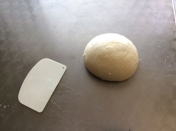 用括板把麵團取出，桌上撒少許的高粉，一手將麵團用力在桌上甩出，一手拿刮板將麵團括回，再甩出，每次收回後要將麵團換個方向，如此不斷甩打，麵團漸趨光滑，並產生筋性，可拉出薄膜。