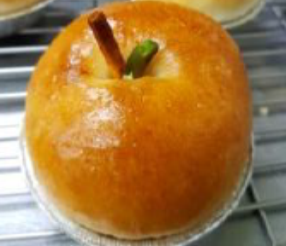 冷卻後裝飾：用溶化後的巧克力將綠色的開心果粒當作蘋果的葉子黏附在麵包中央(如照片)。