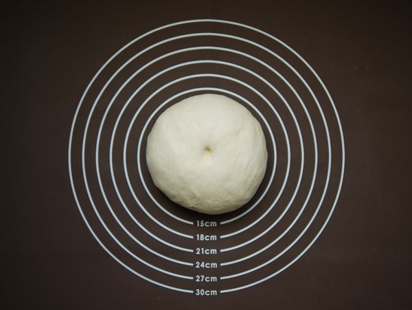 待麵包機『14(麵包麵糰)』模式結束後取出麵糰，工作桌面上撒上少許高粉，將麵團倒在桌面上，以手掌輕拍麵團將內部大氣體排出。