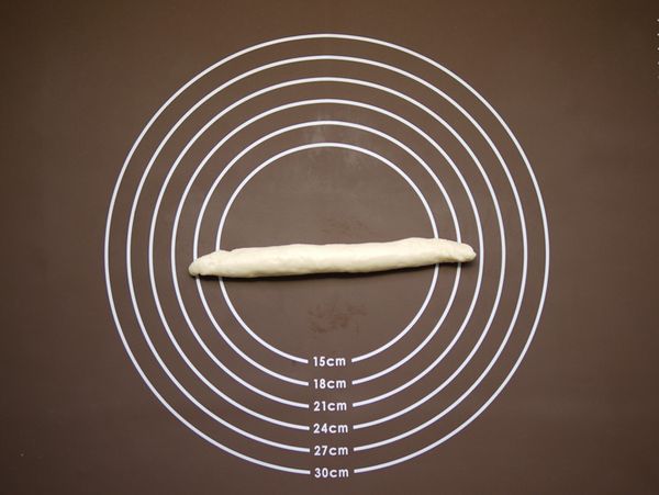 將橢圓形的麵團上而下捲成條，然後把麵團搓成長條，此時可請孩子們協助把麵團搓成長條，在孩子們邊學邊玩的同時，更可訓練他們小肌肉的靈活度呢!!!