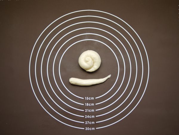 再將鬆弛後的8個13g的小麵團搓成長長的水滴狀，放在完成的小蝸牛殼旁邊，就變成小蝸牛的樣子囉。