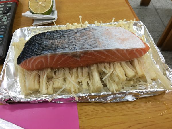 將金針菇去尾部，洗淨後擰乾，鋪平在烤盤上