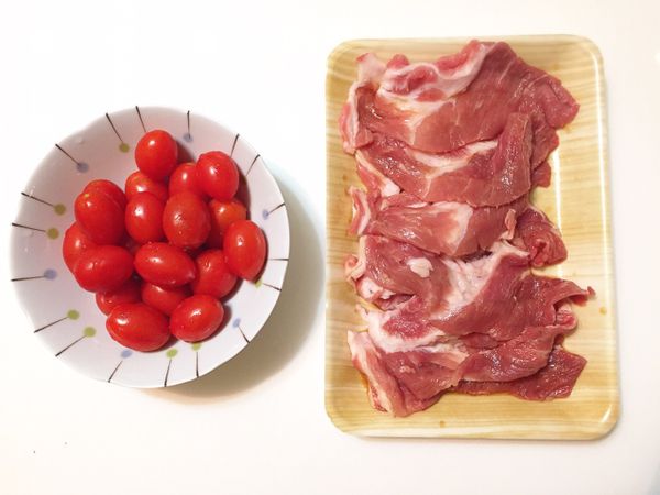 豬肉片先加一匙米酒，兩匙醬油，和一匙水醃個十分鐘，再用一片豬肉把一顆小番茄捲起來