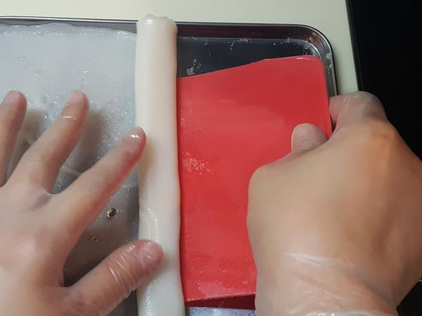 用蛋糕刮刀，在盆邊位開始捲起成腸粉狀即可。