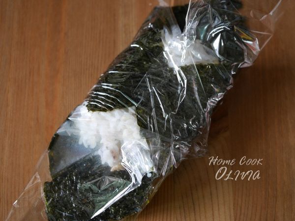 用飯匙壓平整形，將海苔四角折起來緊緊包住。拆掉保鮮膜，切成兩半即可。