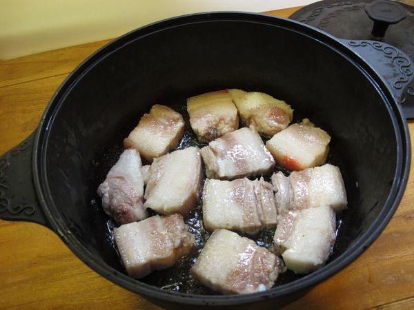 取一深鍋, 倒入兩大匙油、豬肉小火煸至天然油脂釋出