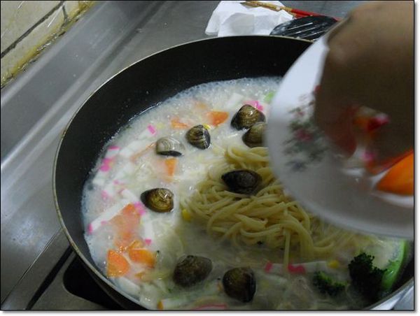 【加料】隨性加入喜愛的蔬果配料，像我就加入小朋友平常喜歡的杏鮑菇、花椰菜、火鍋料、紅蘿蔔、蛤蠣，加蓋烹煮至熟約2分鐘。