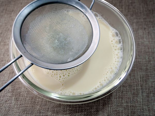 開關跳起，立即取出兩只鋼碗(小心燙手)。快速攪拌洋菜碎預防沉底，並馬上加進熱豆漿中拌勻。接著，用濾網過篩一次，放涼後再移至冰箱冷藏約2小時。