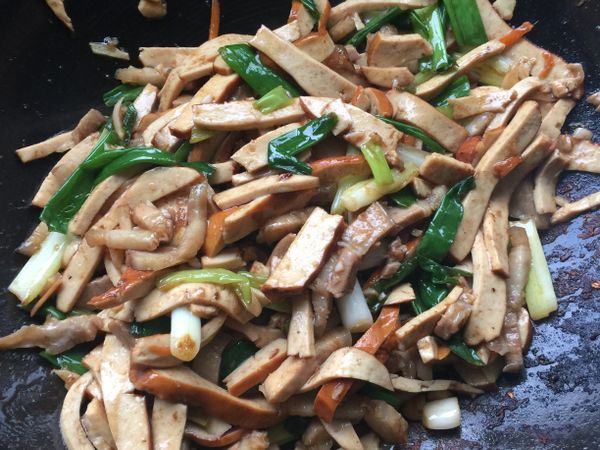 起油鍋先下蔥白和蒜末、豬肉絲爆香炒至香味出來後下燙好的豆乾絲繼續拌炒後下少許的米酒、蠔油、醬油、胡椒粉和剩下的蔥段拌炒均勻即可。