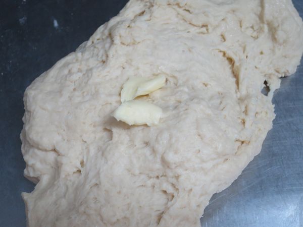 再加室溫軟化的無鹽奶油(分次加入)，搓揉均勻。