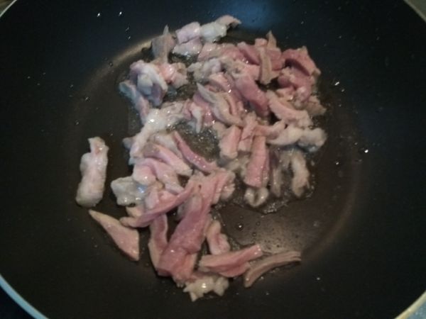 加熱鍋子，倒入橄欖油，將肉絲和蒜末放入爆香。