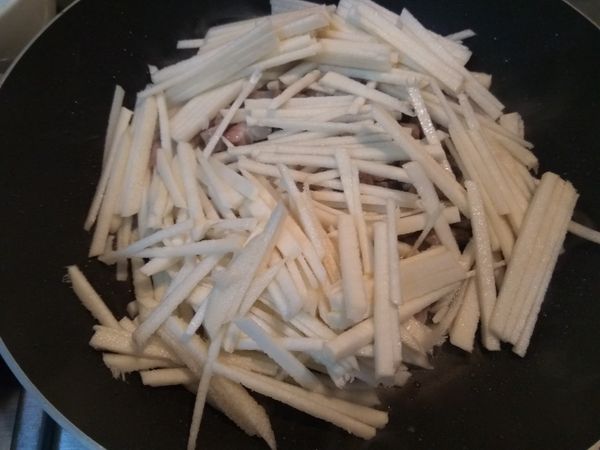 竹筍洗淨切成筍絲，放入鍋中拌炒。