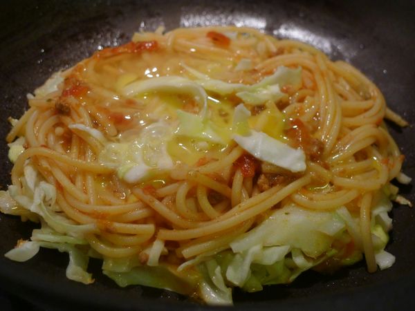 【加料】熱水, 先舖一層高麗菜絲, 再將蕃茄肉醬義大利麵置於其上攤成圓形, 底部微焦後, 再打上蛋汁