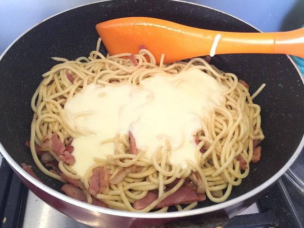 培根切絲炒香，加入煮好的意粉，倒入適量的白汁，加鹽同黑胡椒碎調味。