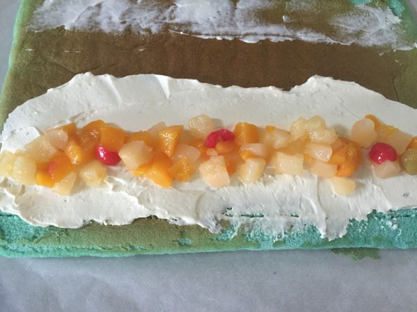 出爐後，立刻移到架子上撕掉全部烤盤紙放涼。
蛋糕體靠近自己的那邊劃三刀不切斷，再鋪上鮮奶油、什錦水果（可自己變化），利用桿麵棍捲起後放置冰箱冷藏兩小時，吃的時候再切片即可。